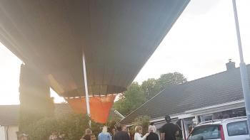 Landade luftballong i familjs trädgård