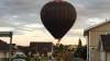 Landade luftballong i familjs trädgård