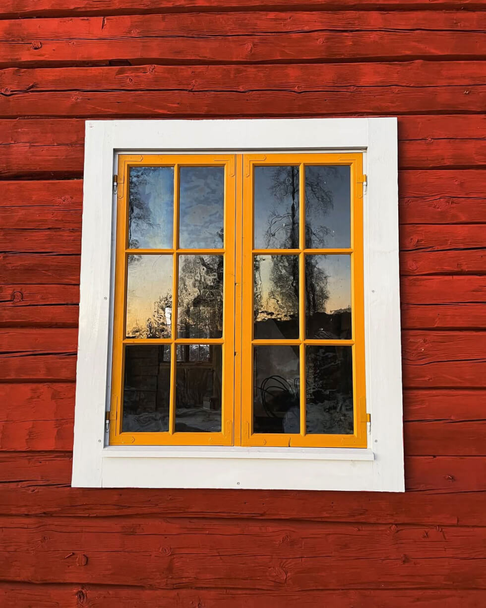 Gult fönster mot en husfasad