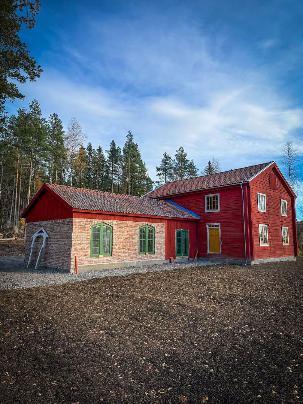 Rött timmerhus med tillbyggnad