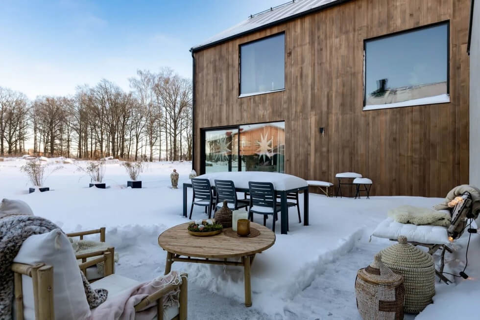 modernt trähus träfasad stora fönster snö uteplats