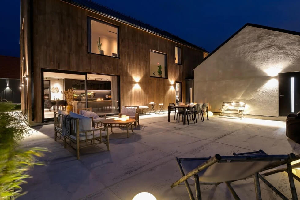 modernt hus träfasad stora fönster uteplats sten