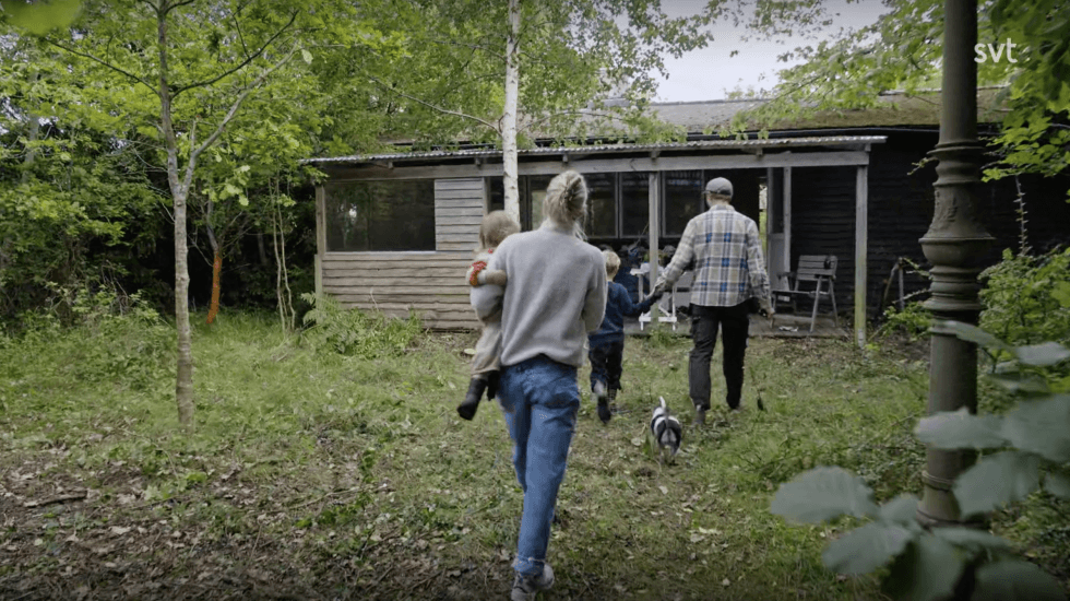 Familjen framför sitt sommarhus som ska renoveras