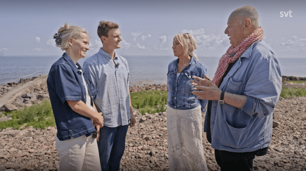Sara, Melker, Anne och Gert står på stenstranden vid havet