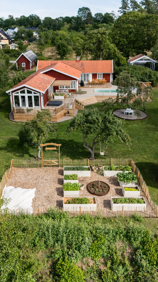Bild på huset uppifrån där pool, altan, torp och den byggda köksträdgården håller på att byggas.