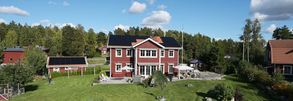 Ett hus med solceller på både hustak och garage.