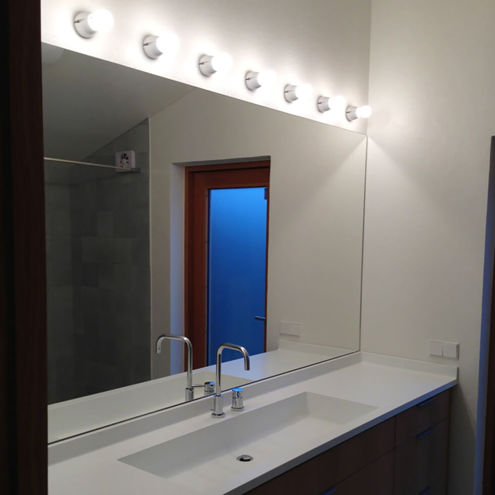 Lampor på en rad över badrumsspegeln ger bra arbetsbelysning.