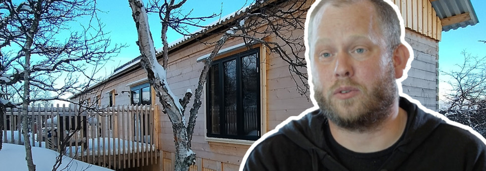 Peter Nilsson vid sitt timmerhus.