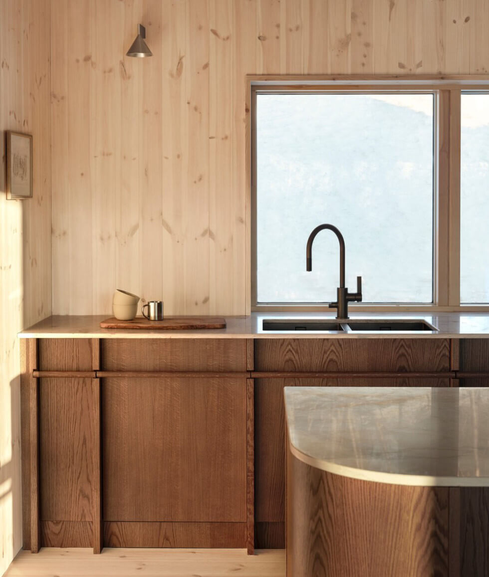 Ett mörkt träkök från Nordiska kök i arkitektritad fjällstuga. 