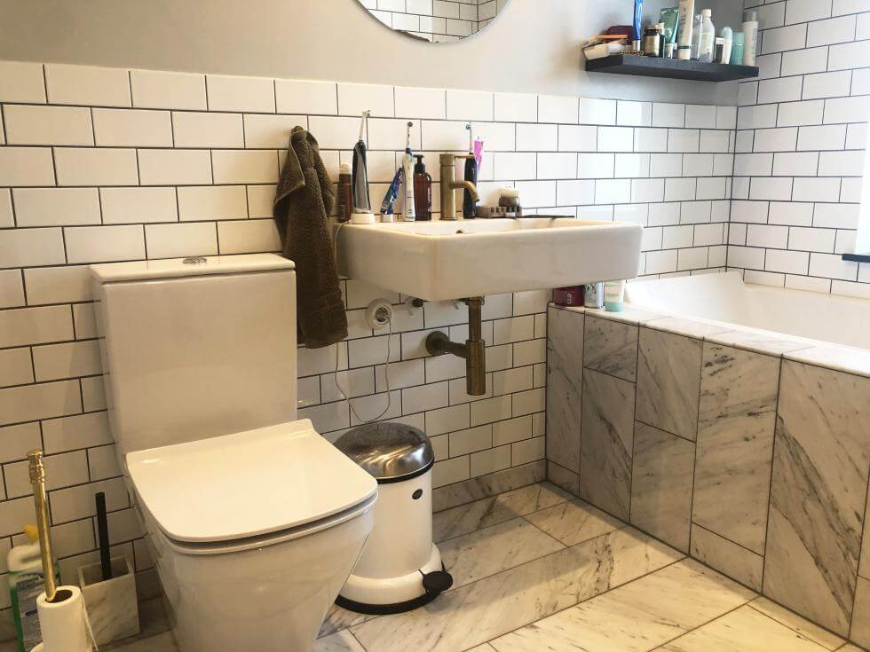 Halvkaklat badrum med inbyggt badkar och Carrara-marmor. 