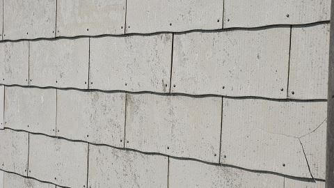 Eternitplattor innehöll förr asbest och kräver därför hantverkare med skyddsutrustning. På bilden ses en omålad eternitvägg.