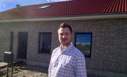 Mikael framför sitt nybyggda hus.