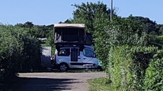 Grannen fyller trädgården med campinggäster